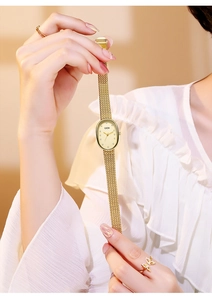 Detail view of oval mother-of-pearl dial with diamond markers and gold mesh strap
