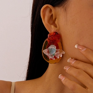 Detail of vintage resin goldfish earrings with a red rose and amber base on model