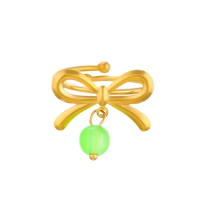 Detail view of a golden bow ring featuring a hanging green round bead pendant and adjustable band