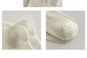 Detailed view of cream knit slouch socks showing reinforced heel and vertical rib texture