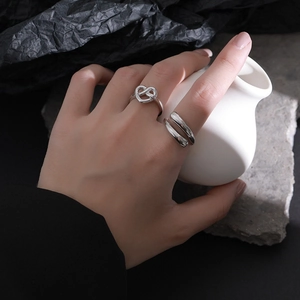 Minimalist S925 sterling silver intertwined heart open ring set on artistic background