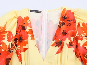 Detail eines gelben Blumen-Maxikleides mit V-Ausschnitt und weißem unsichtbarem Reißverschluss