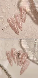 Macro detail of almond press-on nails with white butterfly patterns and pearl accents