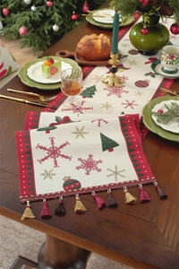 Detail of Christmas table runner with festive tree patterns and multi-colored tassels