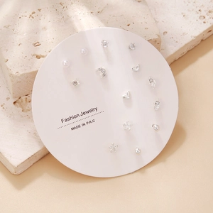Detail of silver stud earring set with pearls and rhinestones on circular card display