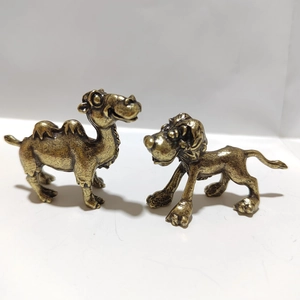 Detailed macro view of vintage brass camel and lion statues with aged metallic texture