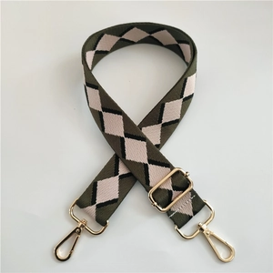 Detail of army green and beige argyle cotton strap with golden metal hardware