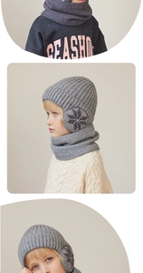 Detail of gray kids knitted beanie and scarf set featuring snowflake pattern and ear flaps