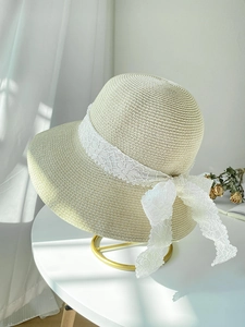 Detailed weave pattern of cream straw sun hat featuring elegant white lace ribbon