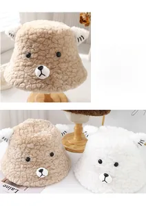 Detailed view of plush bear bucket hats in khaki and white colors with cute 3D ears
