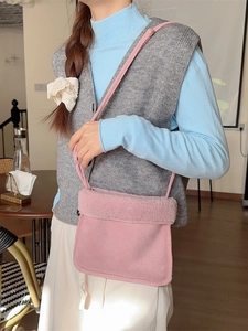 Sac bandoulière en daim rose avec bordure en peluche porté par un mannequin pour l'hiver