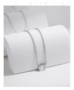 Macro shot of S925 silver necklace featuring an emerald cut pendant on white stands