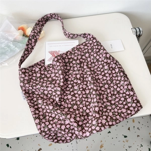 Floral canvas tote bag with pink and purple flower patterns displayed on a white desk