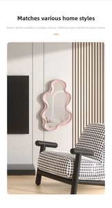 Artistic cloud shaped wall mirror with pink wavy frame in a modern living room