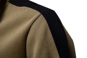 Detail of shoulder stitching on olive green and black patchwork sweatshirt for men