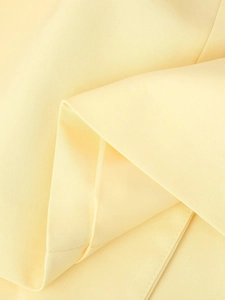 Vue macro du tissu tissé jaune clair montrant la texture et les détails de couture