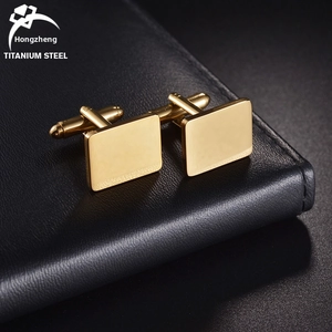 Close-up of golden rectangular stainless steel cufflinks with polished mirror finish