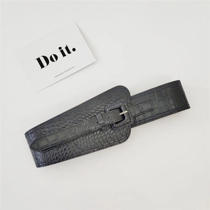 Close-up of a black crocodile pattern wide waist belt with a classic pin buckle detail