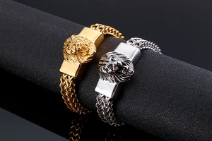 Close-up of gold and silver lion head bracelet with woven metal chain detail