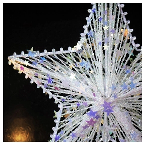 Close-up of a sparkling Christmas tree star topper with purple sequins and glitter finish