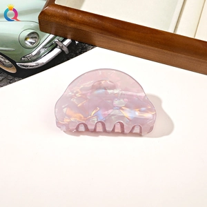 Close-up of pink cloud-shaped resin hair claw clip with pearlescent finish texture