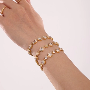 Three stackable gold bracelets with brilliant 5A cubic zirconia on a model wrist