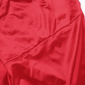 Gros plan sur la texture du tissu rouge et les coutures de cette élégante robe de soirée