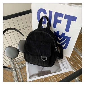 Detail of black corduroy mini backpack texture in a trendy lifestyle shopping cart setup