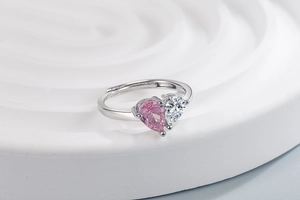 Detail of adjustable open ring featuring pink and clear heart-shaped gemstones in silver