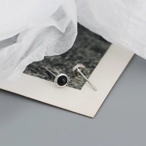 Macro view of S925 sterling silver stud earrings with round black agate inlay detail