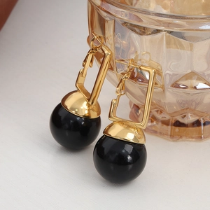 Boucles d'oreilles en acier doré avec rectangle ajouré et pampille boule noire polie