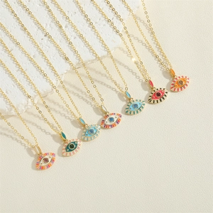 Close-up of colorful evil eye pendants with enamel finish and sparkling zircons on gold chains