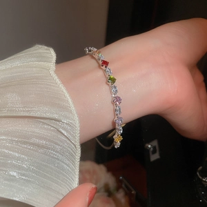 Detail of 18K gold plated bangle with multi-color cubic zirconia on a model's wrist