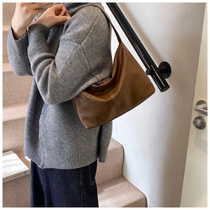 Detail of vintage brown tote bag with decorative stitching on textured synthetic leather