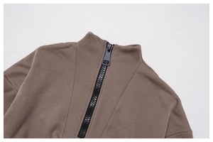 Detail view of the high-quality black metal zipper on a dark brown windproof hoodie jacket