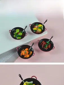 Miniature dollhouse cooking set featuring resin food models in black pans with spatulas