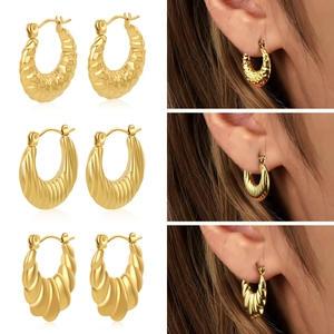 Détails de trois boucles d'oreilles créoles dorées avec textures martelées, rayées et torsadées