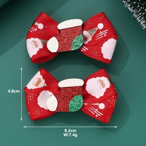 Detail view of red Christmas bow hair clips with Santa Claus print and sequined sock