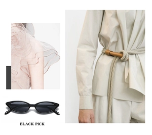 Detail view of black cat-eye sunglasses paired with a beige rope belt and pink ruffled dress