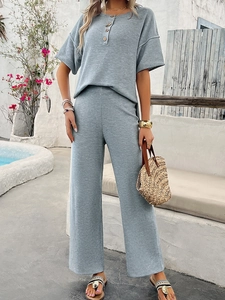 Detail of blue-grey knit two-piece set featuring waffle texture and buttoned neckline