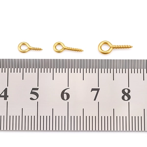 Detailed comparison of three sizes of gold eye pin screw hooks with ruler measurement