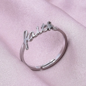 Detail view of Faith engraved 304 stainless steel adjustable open ring on pink silk