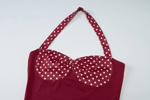 Detailed view of the halter neck tie and pleated bust design on the burgundy polka dot top