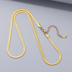 Macro shot of gold stainless steel herringbone chain with a shiny polished mirror finish