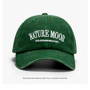 Dettaglio del ricamo NATURE MOOD su un cappellino in cotone lavato verde bosco