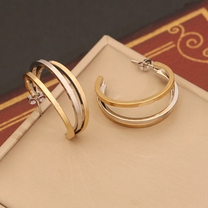 Detail view of two-tone gold and silver C-shaped geometric hoop earrings for women