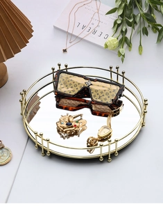 Détail du plateau miroir rond doré montrant le cadre plaqué et la finition luxe