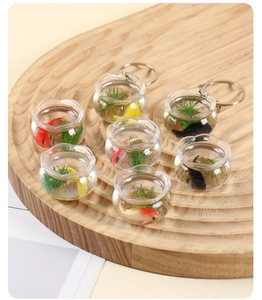 Vue détaillée de porte-clés aquarium miniature avec poissons koi sur plateau bois