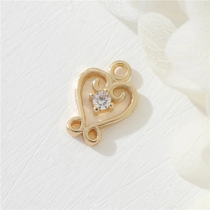 Macro shot of 14K gold plated heart charm with sparkling cubic zirconia inlay