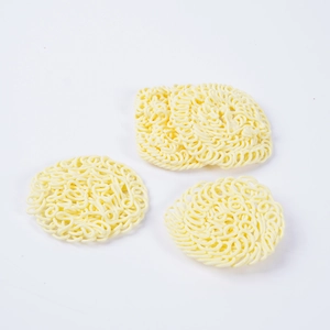 Miniature dollhouse instant noodle props including one square and two round cream ramen pieces